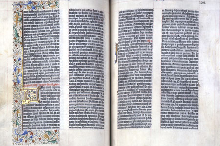 Open book pages showing printed latin text in gothic letters with illuminations.