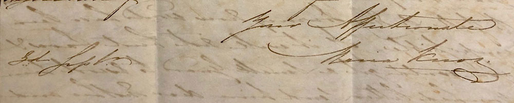 A close up of a cursive signature in brown looking ink on yellowing paper.