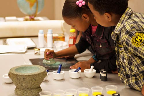 Students preparing pigments to make paint.