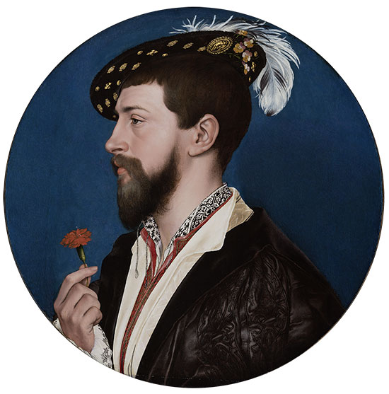 Profile portrait of bearded man holding a flower wearing feathered cap.
