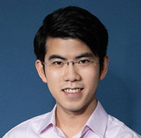 Head shot of Aristo Sham wearing lilac shirt and glasses.