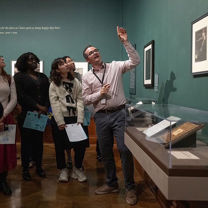 Students standing in a gallery on an exhibition tour.