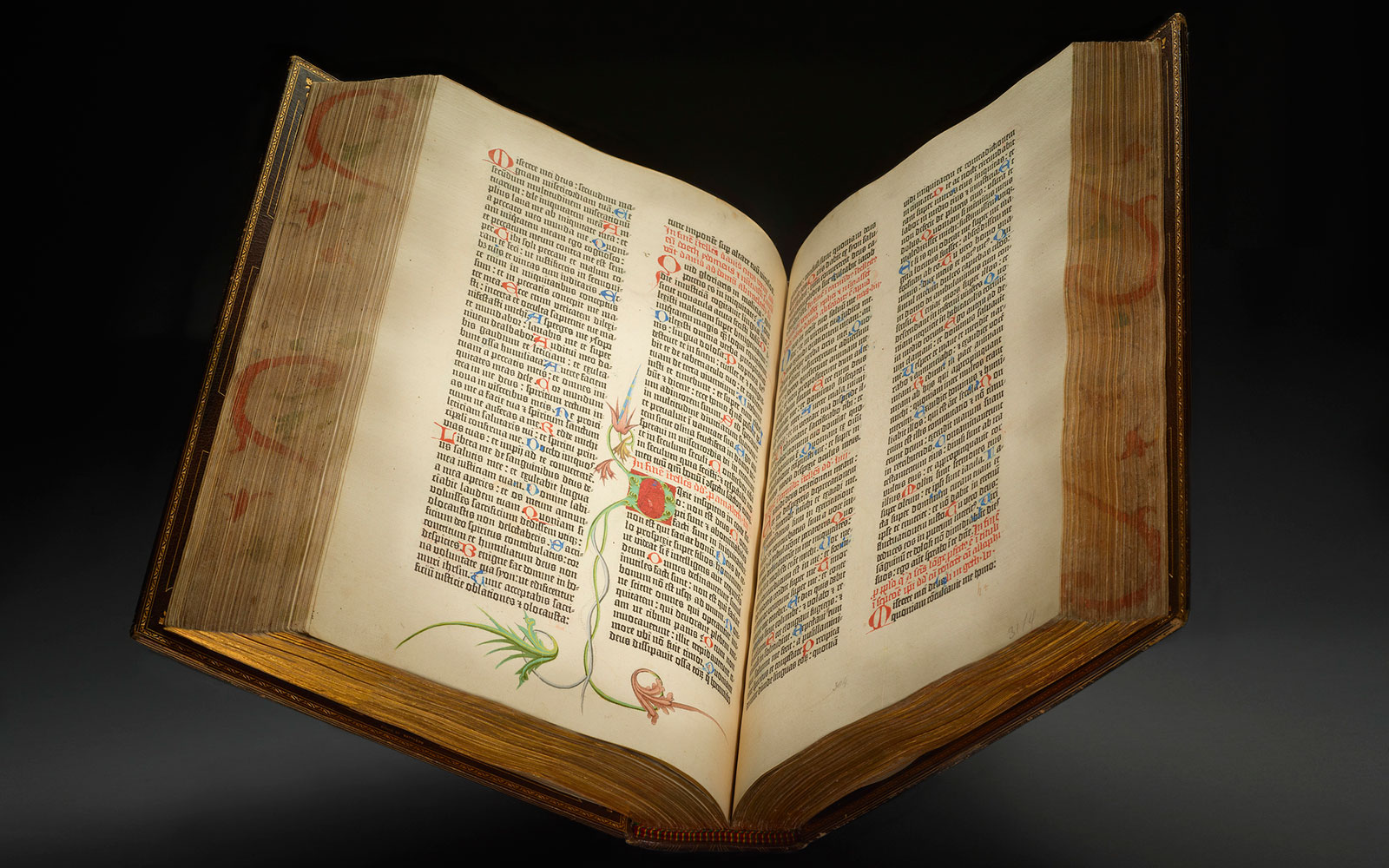 Gutenberg Bible opened to page spread on dark background.