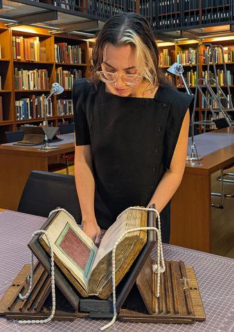 Figure standing over book
