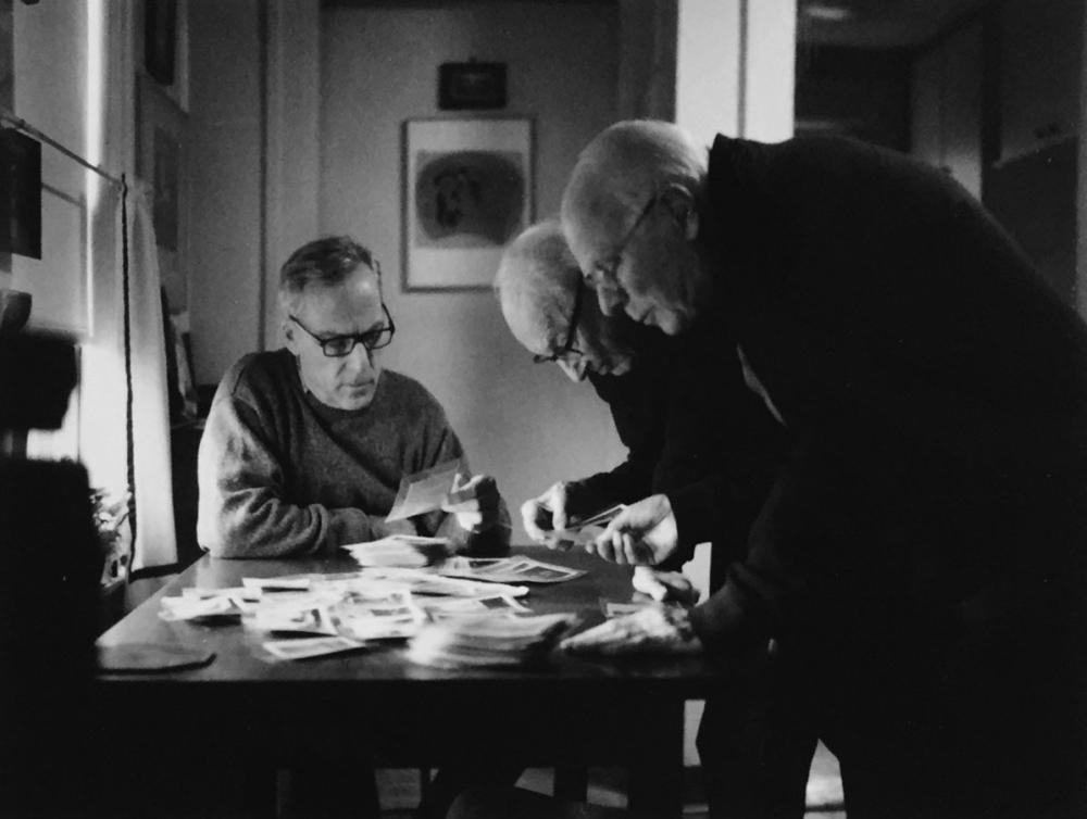 Black and white photoghaph of male figures around a table