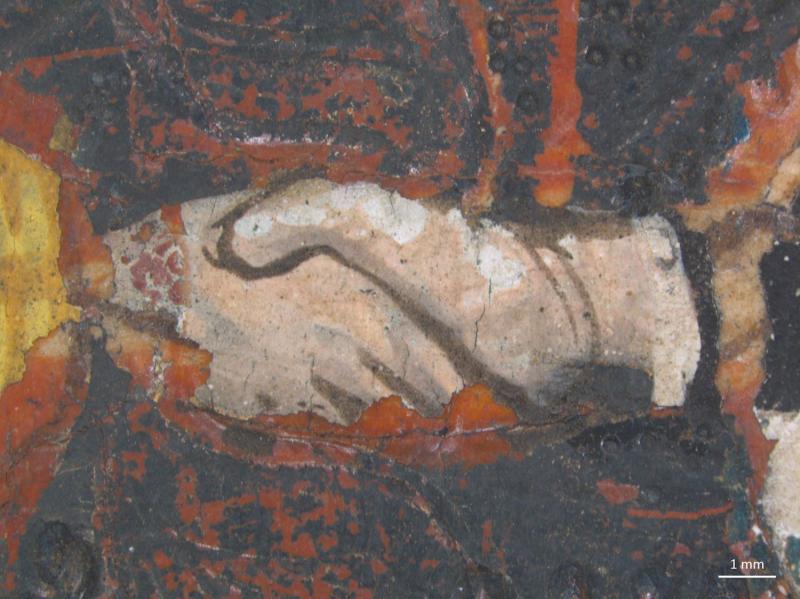 A very close-up detail of a painted surface shows a pale, irregularly shaped area with dark outlines, depicting hands. This central element is surrounded by cracked and flaking paint in dark red, black, and yellow. A 1 mm scale bar is visible in the bottom right corner.