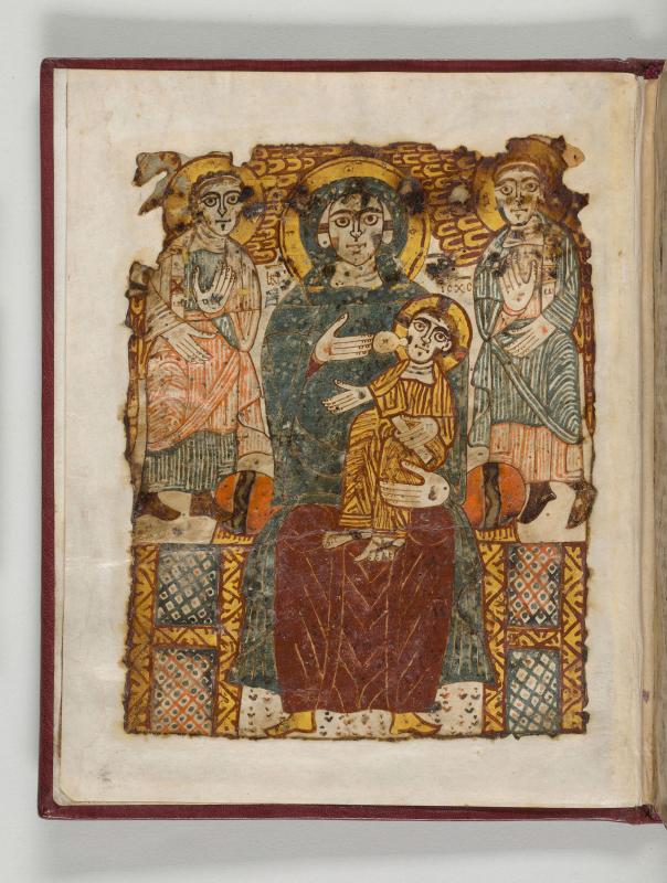 Robed figure in foreground holding a child with figures standing in the background.