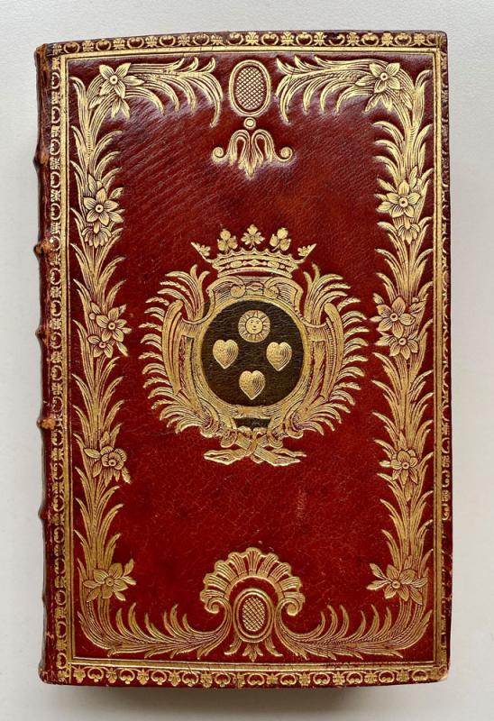 Red leather book binding with gold decoration and coat of arms in the middle.