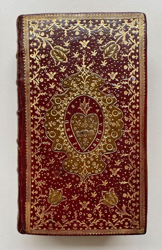 Red leather book bindingheavily decorated with floral gold patterns.