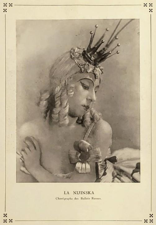 Sepia tone photograph of a woman's head and shoulders. Her hair, or wig is blonde and she is wearing a small crown prop. The text belwo says "La Nijinska"