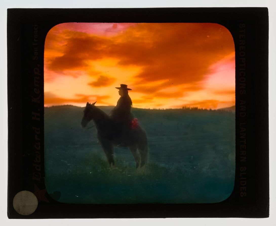 Silhouette of man on horseback with sunset in background.