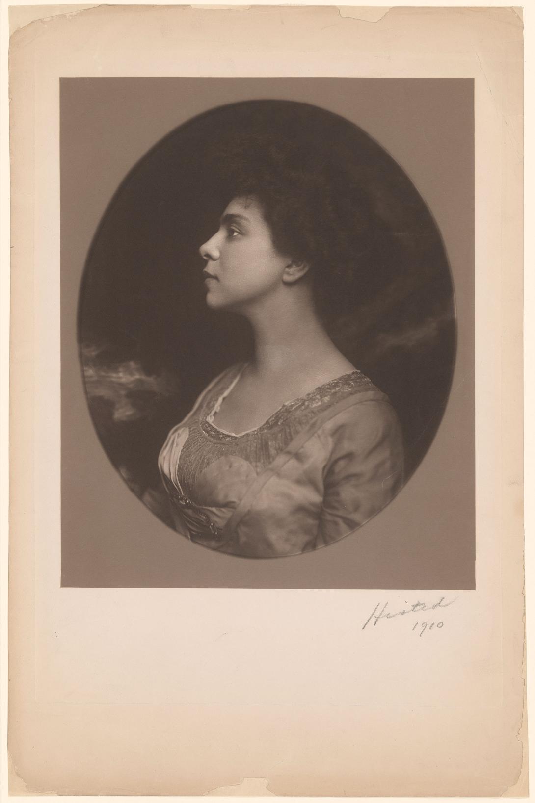 Sepia toned photograph of Belle Greene in profile looking left.